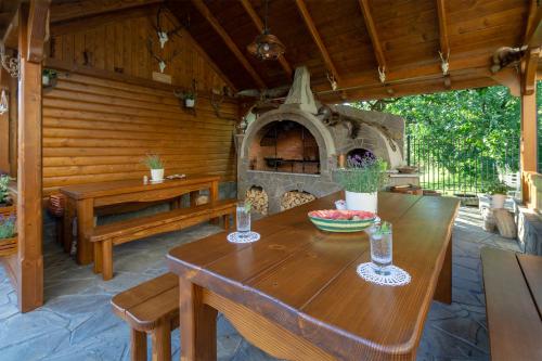 an outdoor patio with a wooden table and a stone oven at Willa Grono in Krościenko