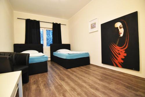 a room with two beds and a painting on the wall at City Apartment am Hildeboldplatz in Cologne