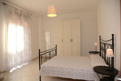 a bedroom with a black bed and a window at Jonico Guest House in Scanzano