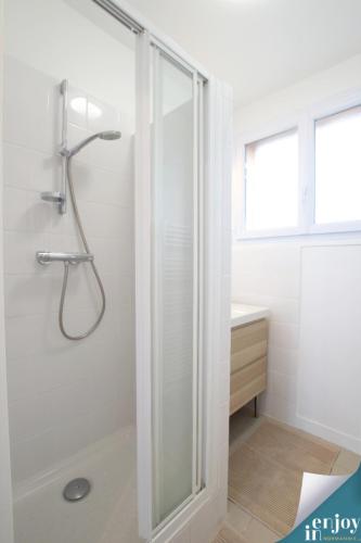 une salle de bain blanche avec une douche et un lavabo dans l'établissement Villa Douce, à Agon-Coutainville