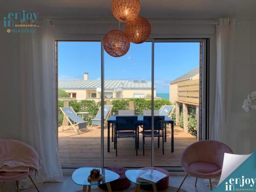 une salle à manger avec une table et une vue sur l'océan dans l'établissement Villa Douce, à Agon-Coutainville