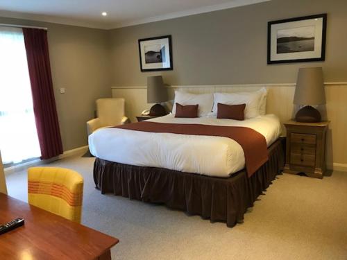 a bedroom with a large bed in a hotel room at Loch Lomond Lodge in Balloch