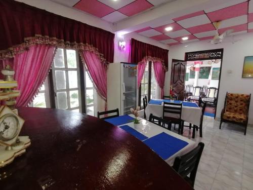 une salle à manger avec une grande table et des chaises en bois dans l'établissement Dilshan Guest, à Polonnâruvâ