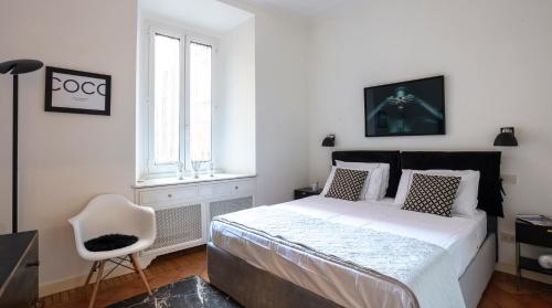 biała sypialnia z łóżkiem i krzesłem w obiekcie Luxury Maison Letizia Piazza di Spagna w Rzymie
