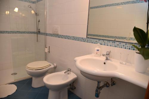 a bathroom with a sink and a toilet and a mirror at Jonico Guest House in Scanzano