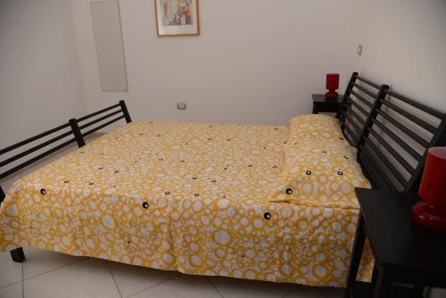 a bedroom with a bed with a yellow comforter at Jonico Guest House in Scanzano