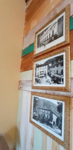 a group of framed pictures of buildings on a wall at Agriturismo Tenuta La Fratta in Bagni di Lucca