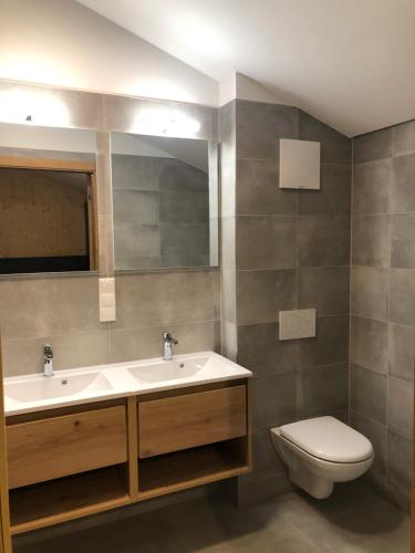a bathroom with a sink and a toilet and a mirror at Villa Kreischberg in Sankt Lorenzen ob Murau