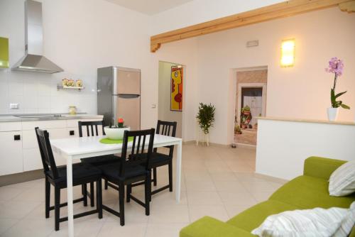 a kitchen and dining room with a table and chairs at Jonico Guest House in Scanzano