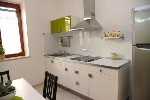a white kitchen with a sink and a refrigerator at Jonico Guest House in Scanzano