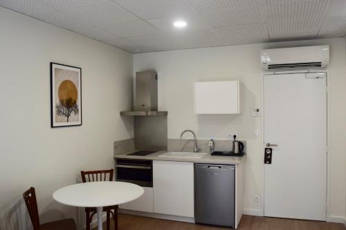 a small kitchen with a sink and a table at Hôtel et appartements les platanes in Thueyts
