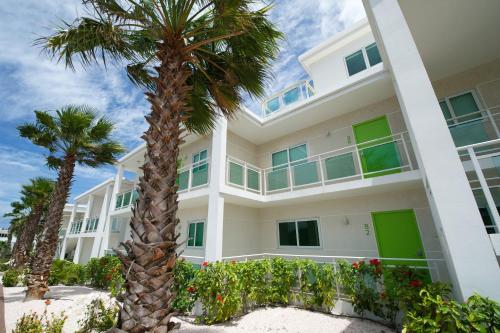 a large white building with palm trees in front of it at Piscadera Harbour Village in Willemstad