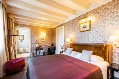 a bedroom with a large bed and a desk at Hotel Moresco in Venice