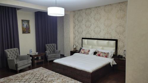 a bedroom with a bed and a table and chairs at HOTEL AYNI in Dushanbe