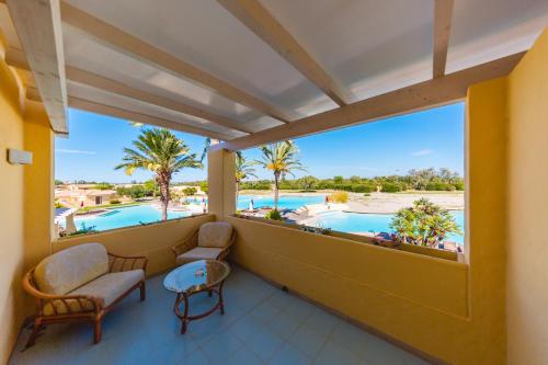 a balcony with a view of the pool and palm trees at Argonauti Greenblu Resort in Marina di Pisticci