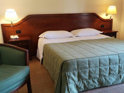 a bedroom with a large bed and a chair at Hotel Villa Peretti in Gela