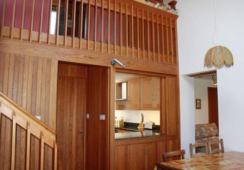 a kitchen with wooden walls and a wooden door at Sylvan Orchard in Gullane