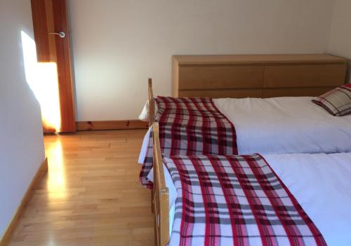 a bedroom with two beds and a wooden floor at Sylvan Orchard in Gullane