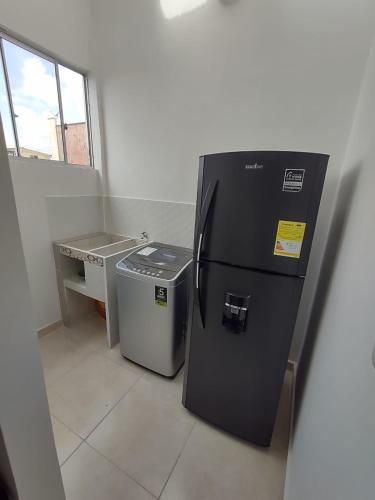 a black refrigerator and a trash can in a room at Hotel Cafe Estrella in Armenia