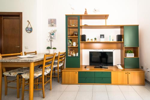 a living room with a dining table and a tv at Sardinia-holiday casa Pesce Palla in La Maddalena