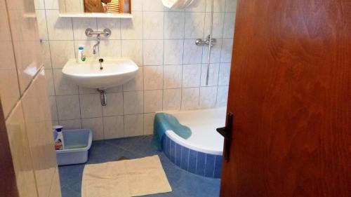 ein Badezimmer mit einem Waschbecken, einer Badewanne, einem Waschbecken und einem WC in der Unterkunft Holiday Home Olib in Olib
