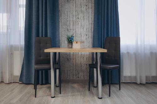 a table with two chairs and a table with a plant on it at Apart-hotel I. Sirko New Building 8 floor in Sumy
