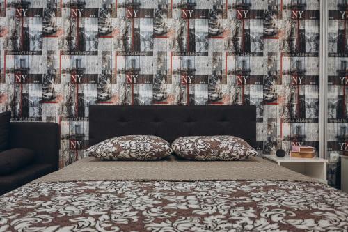 a bed with two pillows in front of a wall at Apart-hotel I. Sirko New Building 8 floor in Sumy