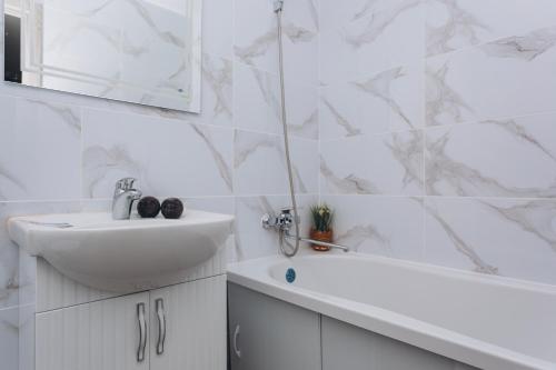 a white bathroom with a sink and a tub and a sink at Apart-hotel I. Sirko New Building 8 floor in Sumy