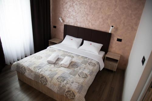 a bedroom with a bed with two towels on it at Hotel "Srbija Tis" in Zaječar