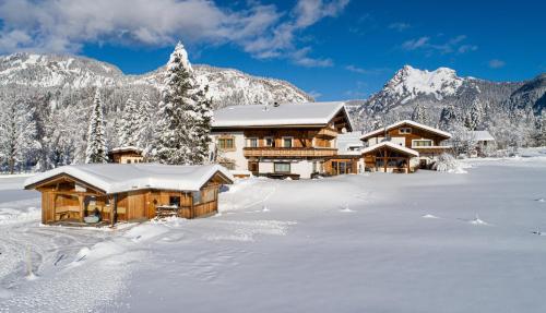 a log cabin in the snow with mountains at Tyroler Hof in Grän