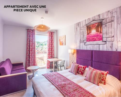 una camera con un grande letto e una testiera viola di Hôtel et Appart Hôtel Les Flots Bleus ad Agay - Saint Raphael