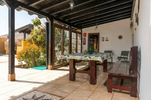 a patio with a table and a bench at Casa rural con piscina privada Manitaga. in Tuineje