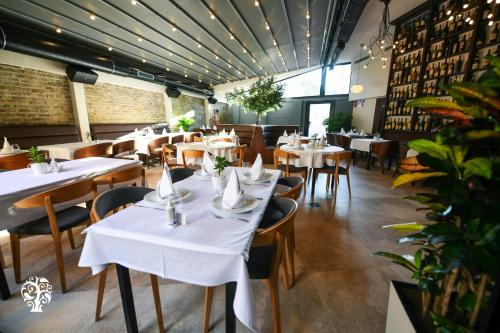 a dining room with white tables and chairs at Agape Villa Apartments in Novi Sad
