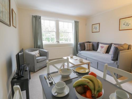 a living room with a table with a bowl of fruit at Maisie's Cottage in Dunblane