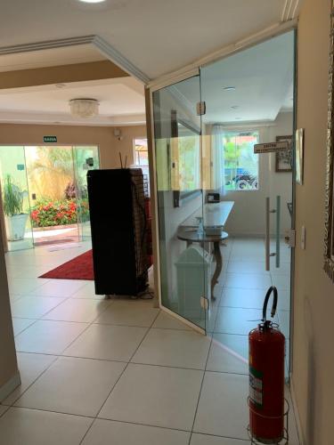 a hallway with a glass door and a red fire extinguisher at Pousada VIP in Pôrto Real