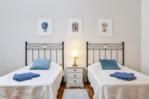 two beds in a bedroom with blue pillows at Casa Maria Dolores in Haría