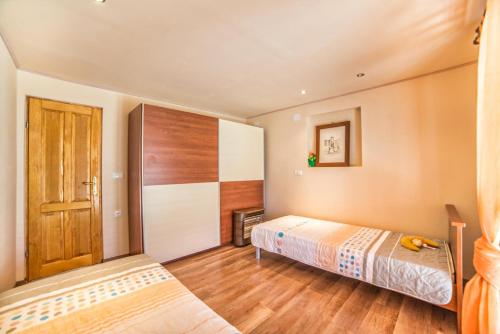 a bedroom with a bed and a wooden door at Holiday House Eleonora in Barban