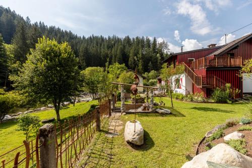 a yard with a fence and a house at Smileys Fluss Chalet in Trebesing
