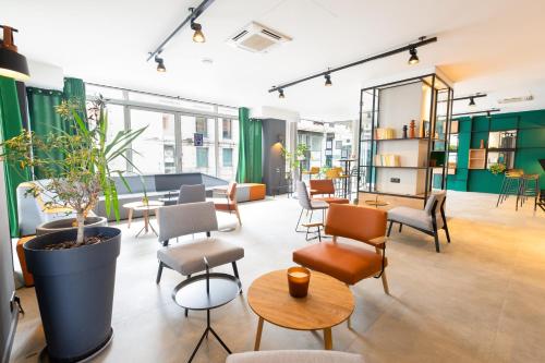 a large room with chairs and tables and plants at Ibis Pau Centre in Pau