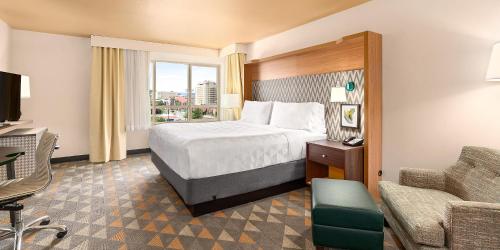 a hotel room with a bed and a chair at Holiday Inn Yakima by IHG in Yakima