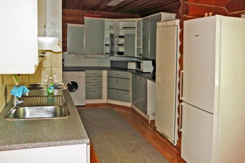 a kitchen with a sink and a white refrigerator at Aronsalmen Lomamökit in Nurmes