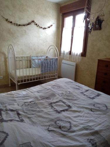 a bedroom with a bed and a crib and a window at Les lutins in Saffloz