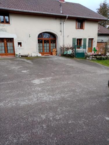 un estacionamiento vacío frente a una casa en Les lutins, en Saffloz