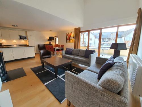 a living room with a couch and a table at Walensee House & Apartments in Unterterzen