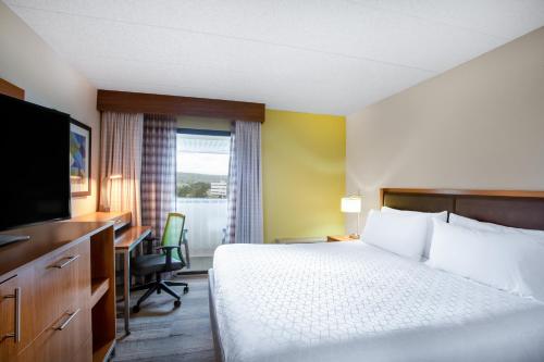 a hotel room with a bed and a desk and a television at Holiday Inn Express Hotel & Suites Philadelphia - King of Prussia by IHG in King of Prussia