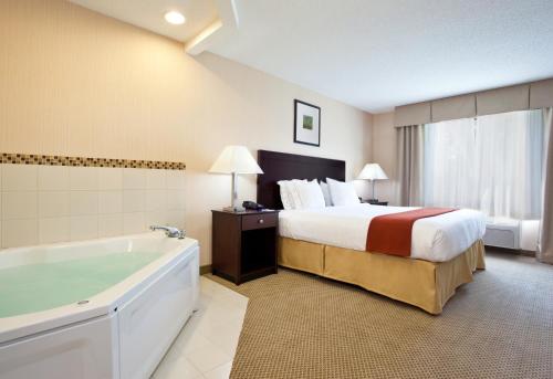 Habitación de hotel con cama y bañera en Holiday Inn Express Hotel & Suites Tipp City, an IHG Hotel, en Tipp City