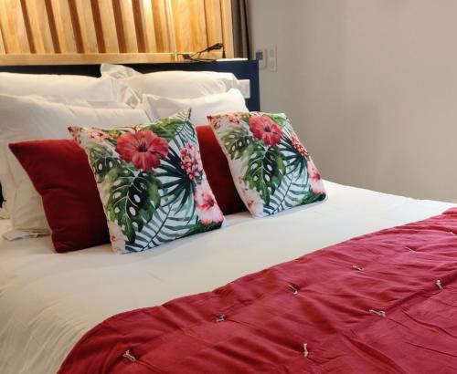 a bed with red and white pillows on it at 5 Chambres en Ville in Clermont-Ferrand