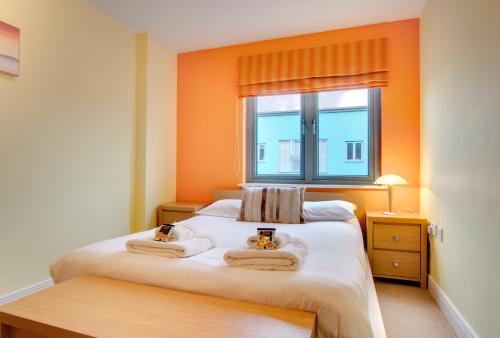 een slaapkamer met 2 handdoeken op een bed met een raam bij Stephenson Sleepers Apartments by Week2Week in Gateshead