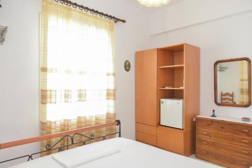a bedroom with a bed and a dresser and a mirror at Kouki Maria Rooms in Apollonia