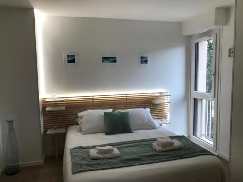 une chambre avec un lit avec deux serviettes dessus dans l'établissement LE STUDIO 35 - charme, parking & proche lac, à Annecy